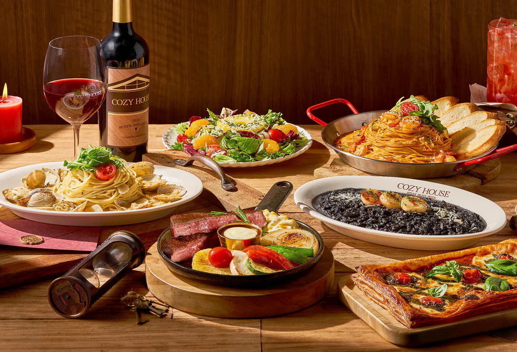 Meja yang ditata dengan berbagai menu termasuk steik dan pasta di COZY HOUSE