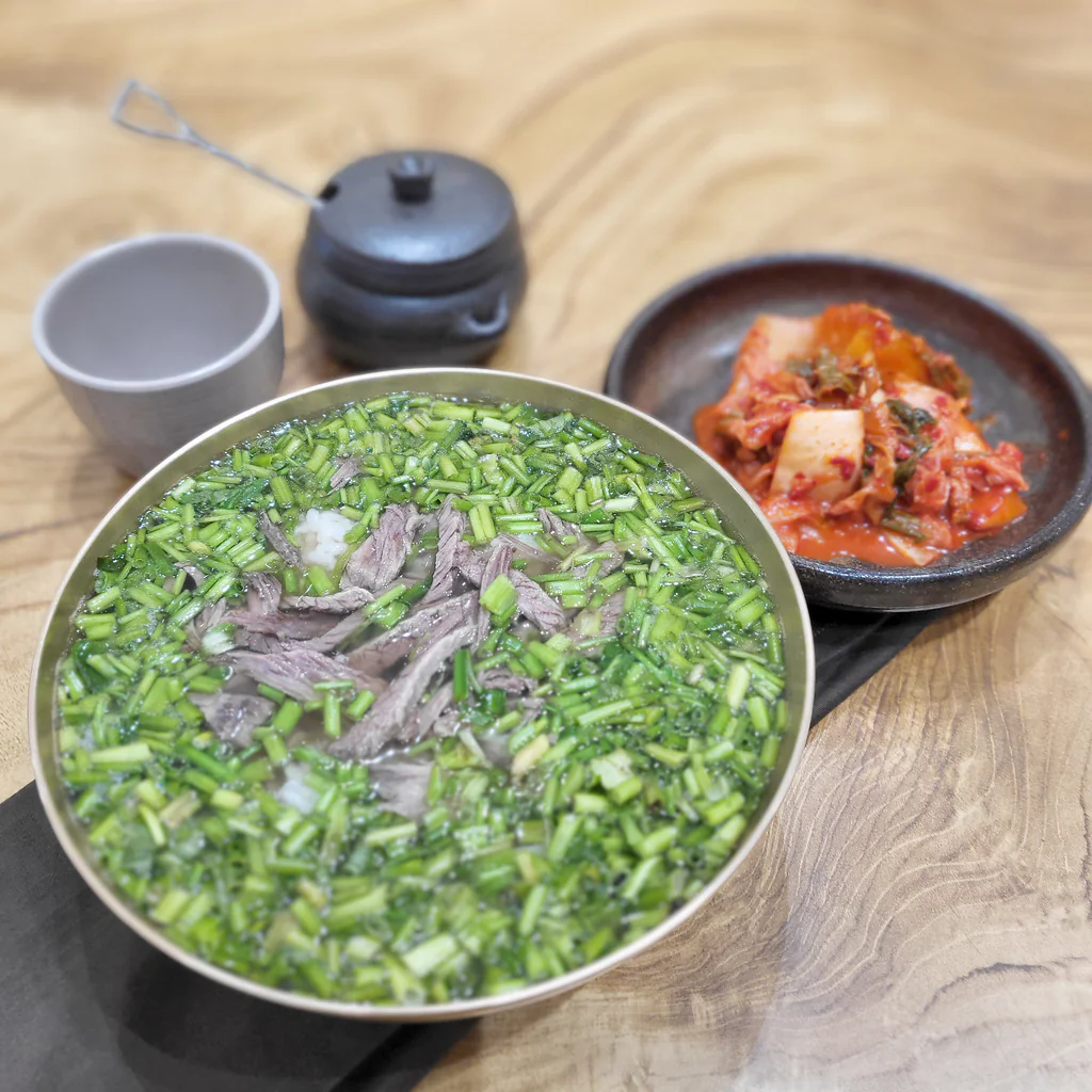 Kuah Geumnyeong Gomtang berisi minari dan daging, disajikan bersama kimchi